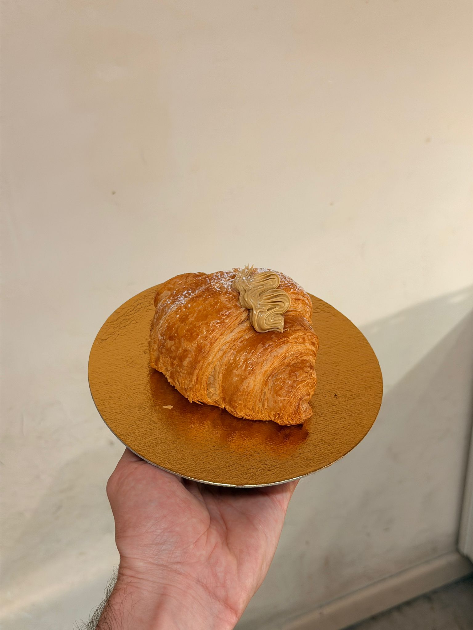 Freshly baked butter croissant held in hand — Boulangerie D'Amore, Nice Côte d'Azur